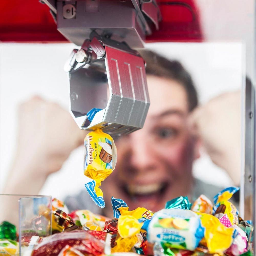 Greifen Sie Süßigkeiten oder einen Spielzeugautomatenspender zum Greifen von Süßigkeiten oder Bonbons