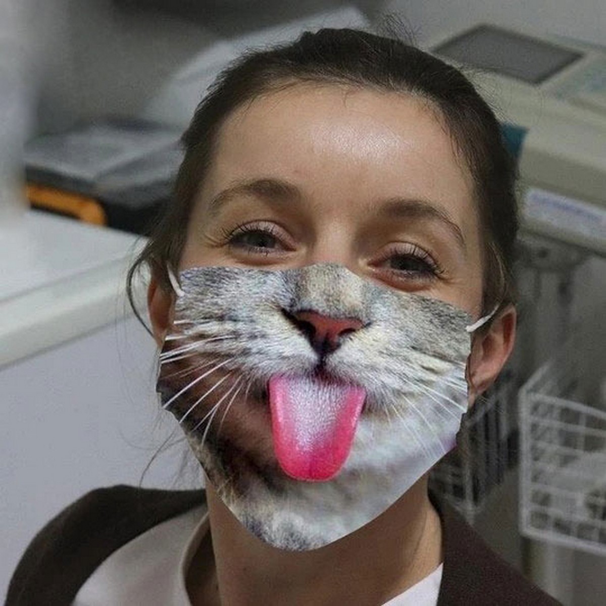 Maske auf dem Gesicht Kätzchen mit Zunge